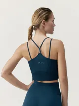 Top deportivo azul de sujeción media, confeccionado en tejido Fit_tech con tecnología 3D. Diseño con nervios y ribs, tirantes cruzados en la espalda.
