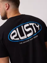 Remera blanca de algodón con logo ovalado de la marca Rusty estampado en el pecho.
