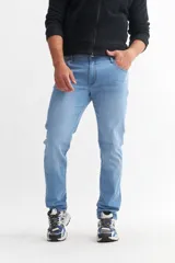 Pantalón de jean azul de corte slim, tiro alto y largo hasta el tobillo.