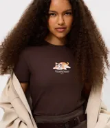 Remera de algodón manga corta, color marrón chocolate, con cuello redondo y estampado frontal de un gato con lentes de sol y la frase 'low social battery'.