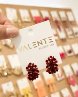 Aros colgantes en forma de racimo floral de color bordó con centro dorado.