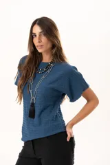 Blusa de silueta relajada y cuello redondo, confeccionada en tela liviana con textura. Presenta mangas cortas y una caída suelta.
