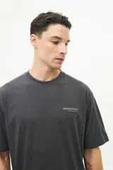 Remera de manga corta color blanco con diseño estampado en la espalda que incluye motivos florales y texto. Presenta un corte regular y cuello redondo.
