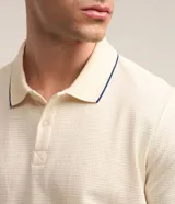 Polo de manga corta marca Marfinno, confeccionada en tejido de algodón con textura tipo waffle. Presenta cuello solapa con detalle de línea en contraste y cierre frontal con botones.
