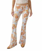 Pantalón acampanado de tiro alto con estampado de flores color naranja sobre fondo celeste.