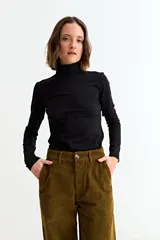 Remera básica de manga larga con cuello polera, confeccionada en tejido suave y elástico.