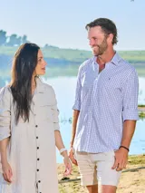 Camisa de vestir de hombre a cuadros celestes y blancos, de corte clásico, con cuello italiano y logo bordado en el frente.
