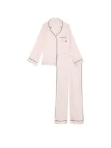 Pijama largo de satín con estampado de rayas verticales en tonos rosados y blancos, compuesto por una camisa de manga larga con botones y ribetes negros, y un pantalón largo a juego.