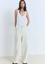 Pantalón de jean estilo wide leg, de tiro medio, con cierre frontal de cremallera y botón, trabillas para cinturón y diseño de cinco bolsillos.