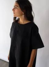 Vestido negro de denim de algodón, corte amplio en A y bolsillos laterales.