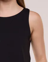 Musculosa negra básica con escote redondo y sisa amplia, confeccionada en tejido suave con doble tela interna en el frente.