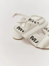 Sandalias de tacón bajo y redondo, con diseño de tiras finas en gamuza y paneles laterales de material translúcido. Cuentan con cierre de pulsera ajustable al tobillo.