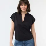 Blusa de manga corta color negro, con cuello en pico y diseño holgado.