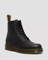 Botas de caña alta Dr. Martens modelo 1460, color negro, confeccionadas en cuero de plena flor con diseño de ocho ojales, cordones negros y suela gruesa con costuras amarillas características de la marca.