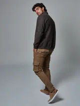 Pantalón cargo color marrón claro, de corte slim, con bolsillos laterales con tapeta, bolsillos frontales y traseros, y aplique de cuero sintético.