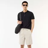 Bermuda chino color gris claro, de corte recto, con cintura elástica ajustable mediante cordón y bolsillos laterales.