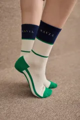 Medias de caña media con diseño tricolor en blanco, verde y azul marino. Presentan el logo de la marca bordado en la parte superior y puntera y talón reforzados en color verde.