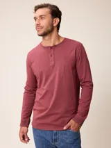 Remera de manga larga con cuello redondo y cierre frontal con botones, confeccionada en algodón. Presenta un pequeño logo bordado en el pecho.