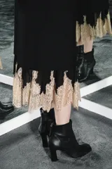 Botín de cuero negro con punta cuadrada y cierre de cremallera trasera. El tacón es ancho y mide 8,5 cm de alto.