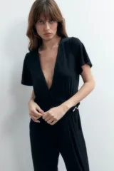 Mono largo de lurex negro con escote cruzado, mangas cortas y corte palazzo.