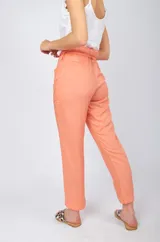 Pantalón color salmón, de corte recto, con bolsillos laterales y lazo de la misma tela para ajustar a la cintura.