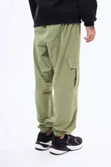 Pantalon cargo negro de corte holgado, con bolsillos laterales con solapa y puños elásticos en los tobillos. Cuenta con cintura elástica con cordón de ajuste.