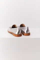 Mocasín de cuero color caramelo, estilo borla, con costura decorativa en el empeine y suela de cuero de bajo perfil.