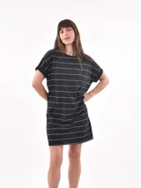 Vestido corto negro con rayas horizontales blancas, cuello redondo, mangas cortas con dobladillo y un bolsillo de parche en el pecho.