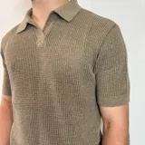 Chomba de tejido de punto con textura, color beige, de manga corta y cuello polo con cierre frontal parcial.