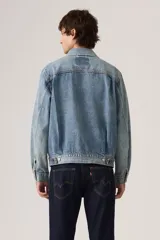 Campera de denim azul con lavado medio, diseño clásico de trucker con bolsillos delanteros con solapa y botones metálicos.