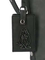 Cartera tipo tote de la marca Hush Puppies, color negro, con diseño minimalista y cierre superior. Incluye un colgante decorativo con el logo de la marca y correas ajustables.