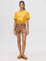 Remera amarilla de ajuste holgado y corte cuadrado, con cuello redondo, mangas cortas y estampa de estrella de cuatro puntas en el pecho.