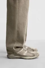 Zapatilla deportiva tipo running de color negro, perteneciente a la colección especial Origins. Presenta una parte superior confeccionada en una combinación de cuero con acabado de gamuza y tejido transpirable. Cuenta con una suela de volumen con diseño irregular y cierre mediante cordones.