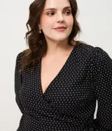 Blusa de crepé con estampado de lunares, diseño cruzado con escote en V, mangas largas con puños elásticos y lazo lateral ajustable. Incluye forro interno.