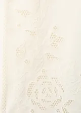 Pantalón palazzo color blanco con detalles bordados en el bajo de las piernas, tiro medio y cintura elástica con cordón ajustable.