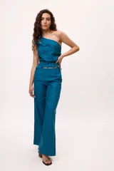 Top de un solo hombro color azul, con diseño irregular, doble tira y detalle de volados en el frente. Confeccionado en una mezcla de algodón y lino.