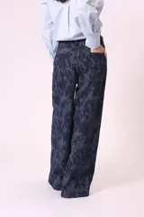 Pantalón de jean de corte ancho con estampado abstracto en tonos azules.