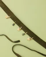 Gargantilla tipo choker de gamuza con dijes colgantes artesanales de metal y perlas naturales. Cuenta con tiras largas para atar y ajustar en la parte posterior.