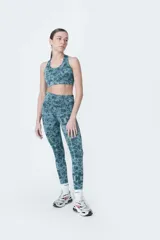 Calza deportiva larga de poliéster y elastano, color verde azulado con estampado abstracto.