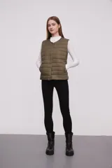 Chaleco acolchado color verde militar con cierre de botones a presión.