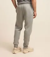 Pantalón deportivo de corte jogger, color negro, con cintura elástica ajustable mediante cordón, bolsillos laterales y puños acanalados en los tobillos. Confeccionado en tejido de algodón con interior felpudo.