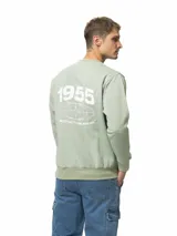 Buzo de felpa color azul marino con cuello redondo, puños y ruedo acanalados. Presenta un estampado frontal con el número 1956 y un diseño de círculos entrelazados.