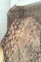 Body de microtul con estampado animal print de serpiente, de manga larga y cuello redondo, con aberturas laterales pronunciadas en la cintura.