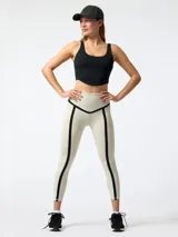 Top deportivo negro de corte crop, con costuras visibles de inspiración corsetera en el pecho, tirantes anchos y espalda rebajada.