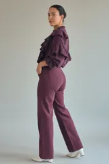 Jean de tiro alto color bordó, con corte recto y bolsillos traseros aplicados. Presenta un diseño de costuras reforzadas y una silueta que estiliza la figura.