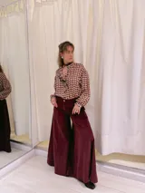 Pantalón de terciopelo color borgoña, de tiro medio y corte acampanado.