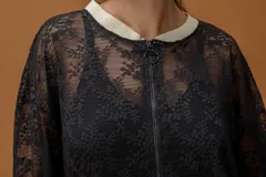 Campera tipo bomber confeccionada en encaje negro con detalles en color dorado en cuello, puños y ruedo. Presenta cierre frontal completo y diseño de mangas largas.