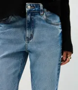 Pantalón de jean corte recto con cintura tradicional, bolsillos funcionales, trabillas para cinturón y cierre frontal con cremallera y botón. Confeccionado en tejido de algodón con un toque de elastano para mayor comodidad.