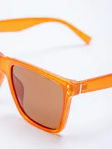 Lentes de sol con armazón de plástico color naranja y lentes marrones con filtro UV400. Incluyen estuche rosado.