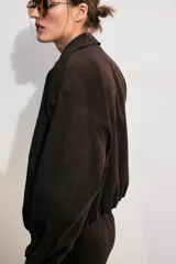 Cazadora bomber de Zara color bordó con cuello de solapa, manga larga, bolsillos delanteros de vivo, bajo elástico y cierre frontal de cremallera metálica.